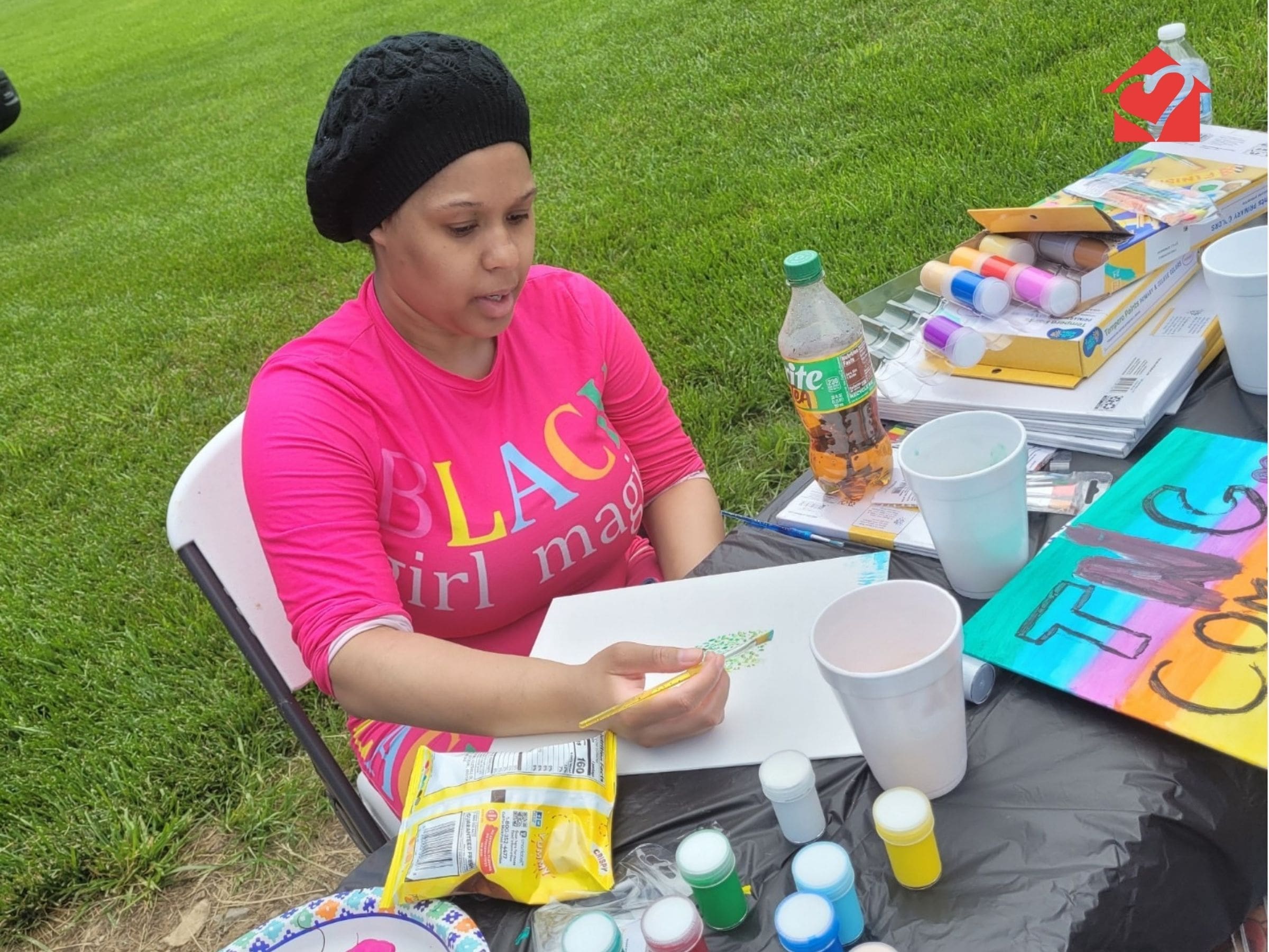 Community connections individual painting outside at Spring Fun Day